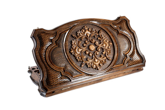 Exquisite hand-carved ornamentation on a luxurious wooden backgammon set.